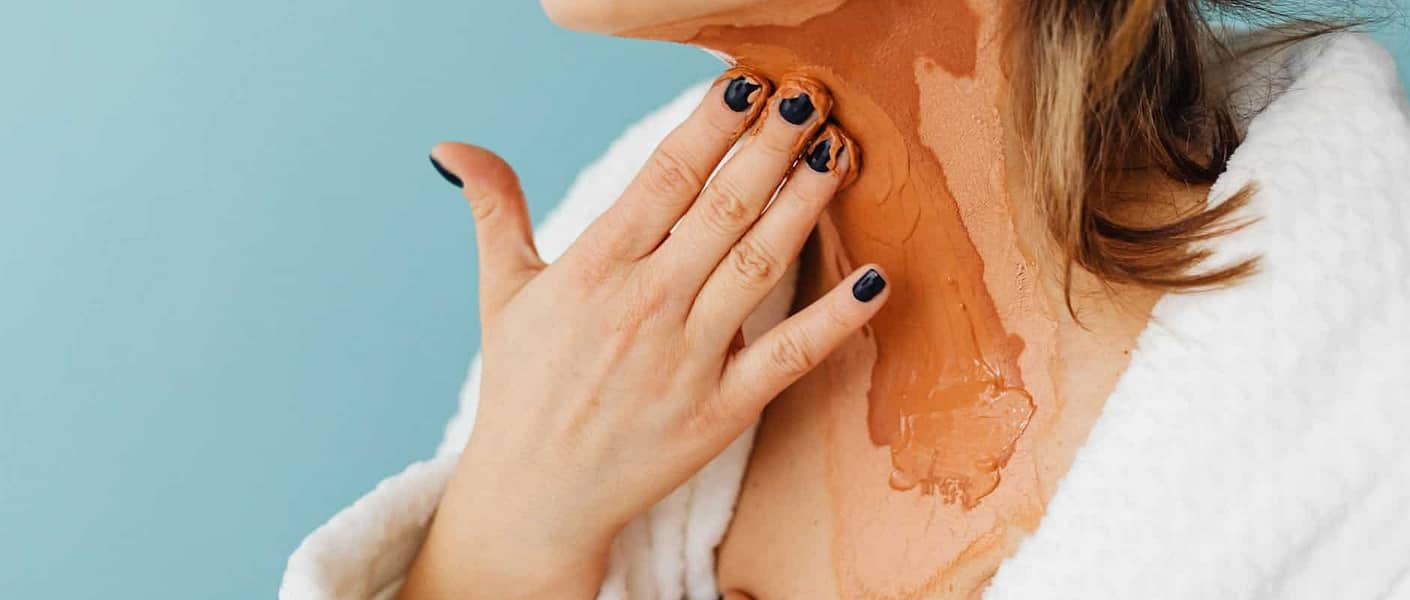 woman putting a skin treatment product on her neck