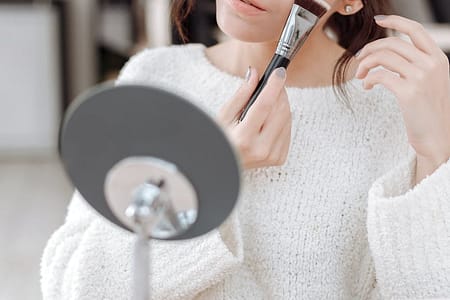 woman applying blush on on her cheek