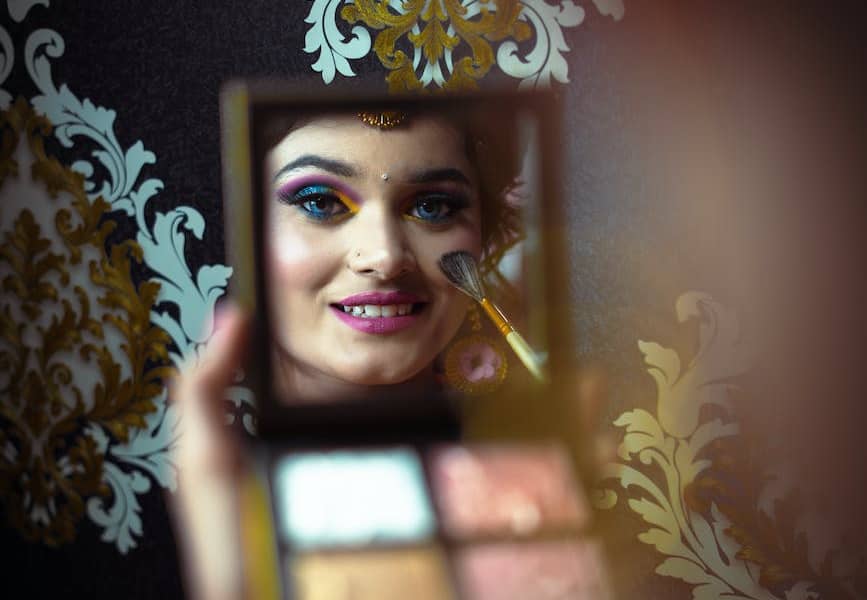 reflection of woman doing makeup